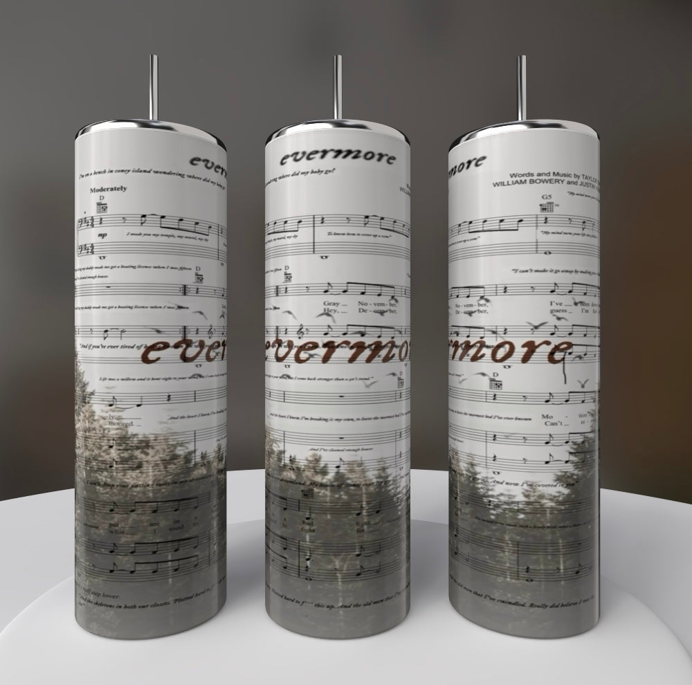 Three tall cylindrical sculptures resembling Kreative Kreationz's Taylor Swift Evermore 20oz Skinny Tumbler exhibit musical notes and "evermore" text. The lower half showcases a forest print, arranged on a circular platform against a dark backdrop, evoking durable construction.