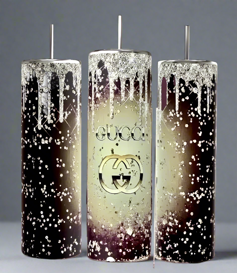 Three tall Kreative Kreationz candles, designed in a dark brown to cream gradient with metallic drips and speckles, echo luxury. The center candle features the iconic "GUCCI" logo and double-G symbol. Each single-wick piece embodies timeless elegance.