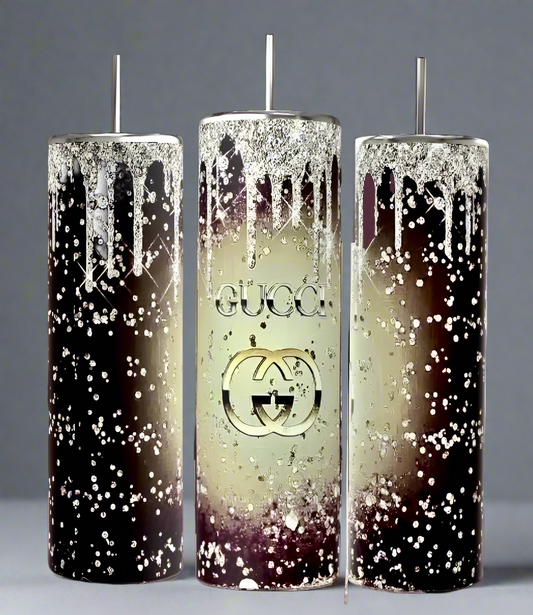 Three tall Kreative Kreationz candles, designed in a dark brown to cream gradient with metallic drips and speckles, echo luxury. The center candle features the iconic "GUCCI" logo and double-G symbol. Each single-wick piece embodies timeless elegance.