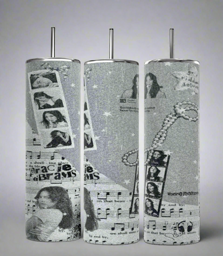 The Kreative Kreationz Gracie Abrams Picture Collage 20oz Skinny Tumbler features a grayscale collage design that includes images of a woman, musical notes, filmstrips, stars, and text elements. These stylish cylindrical tumblers come with reusable straws protruding from the tops.