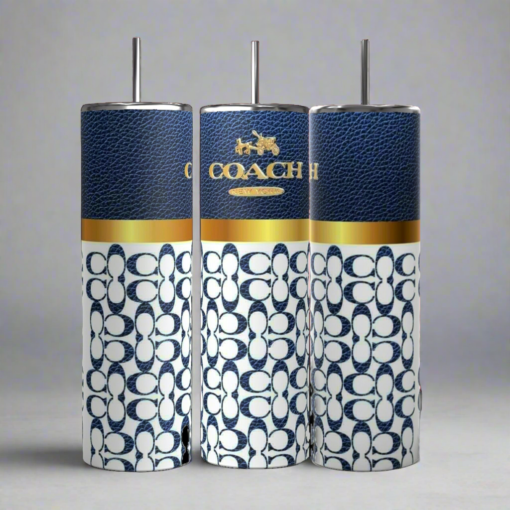 Three Coach-inspired dark blue 20oz tumblers from Kreative Kreationz, each accompanied by a metal straw, are displayed. These tumblers showcase a textured dark blue upper section featuring the "COACH" logo in gold and a white lower section adorned with a blue Coach pattern. The tumblers are aligned side by side against a grey background.