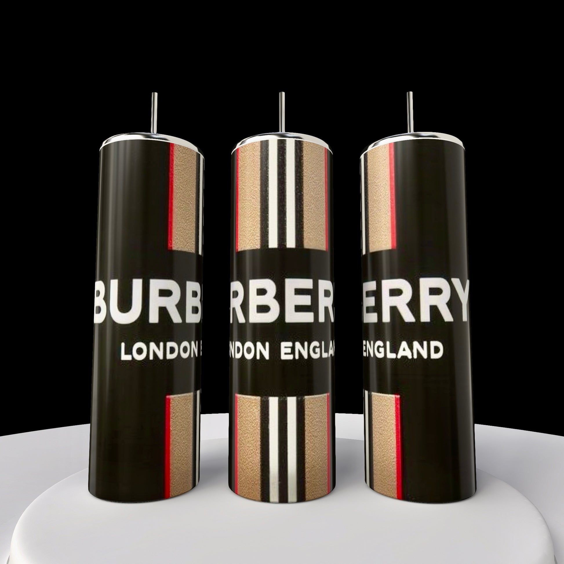 Three 20oz Skinny Tumblers from Kreative Kreationz are displayed on a white platform against a black background. Each features the large "Burberry London England" logo with a red, black, and beige striped design and has double-wall insulation for lasting temperature control.