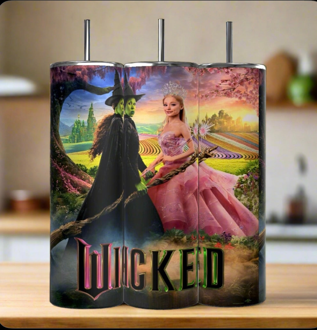 On a table, three Kreative Kreationz 20oz tumblers display vibrant sublimation prints from "Wicked." One depicts the green-skinned Witch, another features Glinda in her pink gown, and the third shows both with the title. The insulated stainless steel designs pop against a blurred kitchen backdrop.