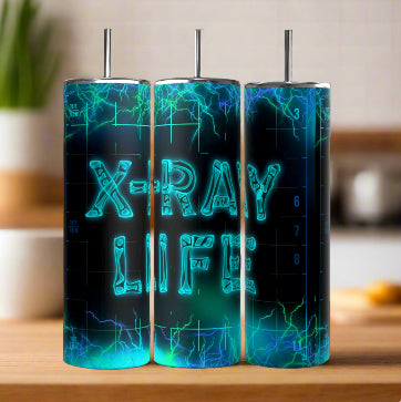 Three Kreative Kreationz X-Ray Tech 20oz Tumblers with futuristic designs sit on a wooden surface. They feature electric blue-green "X-RAY LIFE" text against dark backgrounds, showcasing their durable construction in a kitchen setting.