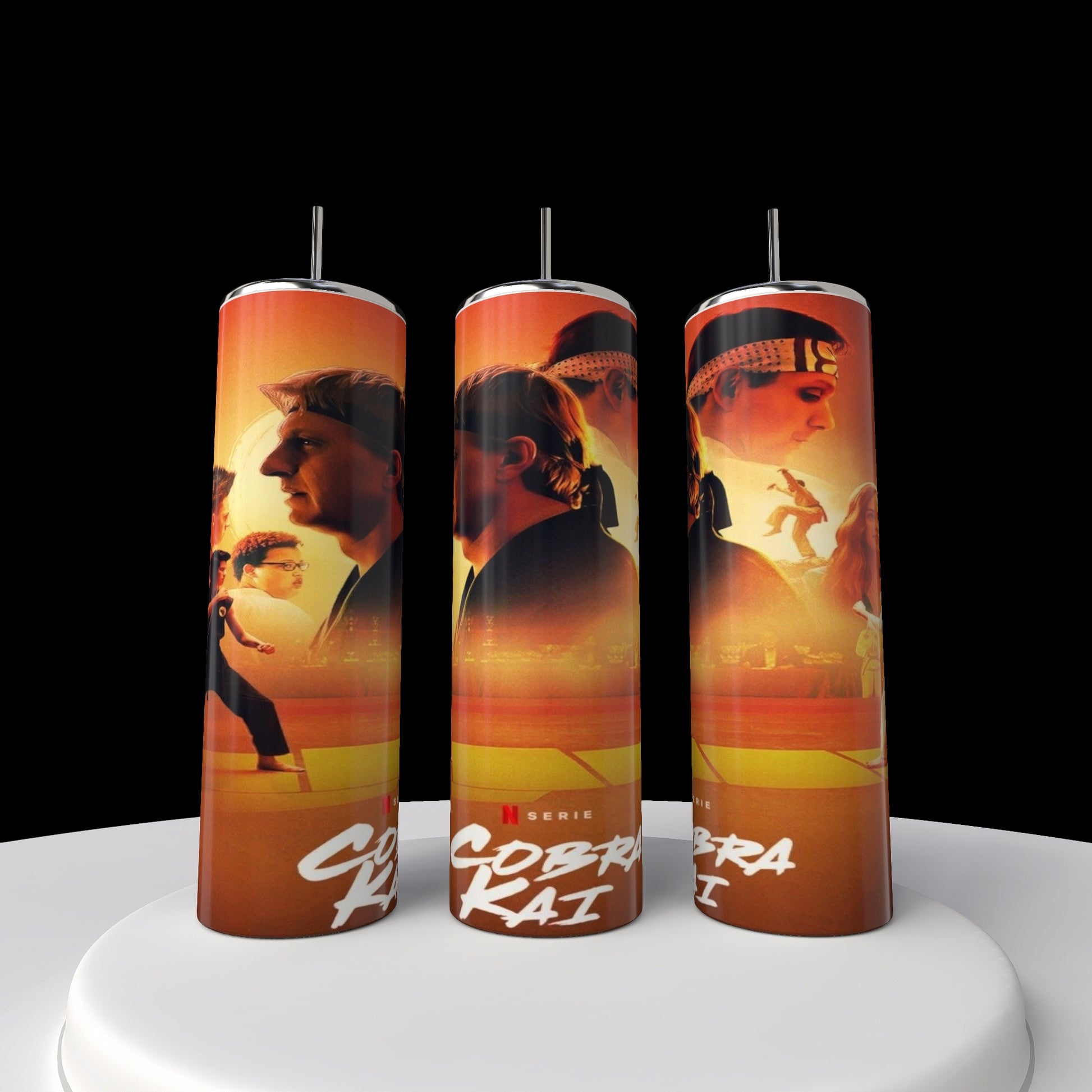 Three Kobra Kai 20oz stainless steel tumblers by Kreative Kreationz display vivid martial artists against a fiery orange backdrop, standing upright on a white platform that contrasts with the black background.