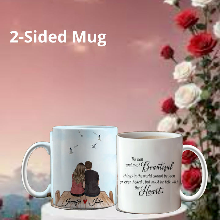 The Personalized Couples Ceramic Mug by Kreative Kreationz embodies a thoughtful gift, featuring a couple on a dock with birds, names personalized. The reverse displays a heartfelt beauty quote amid blooming red and white roses against a pink sky—a perfect personalized couples mug.