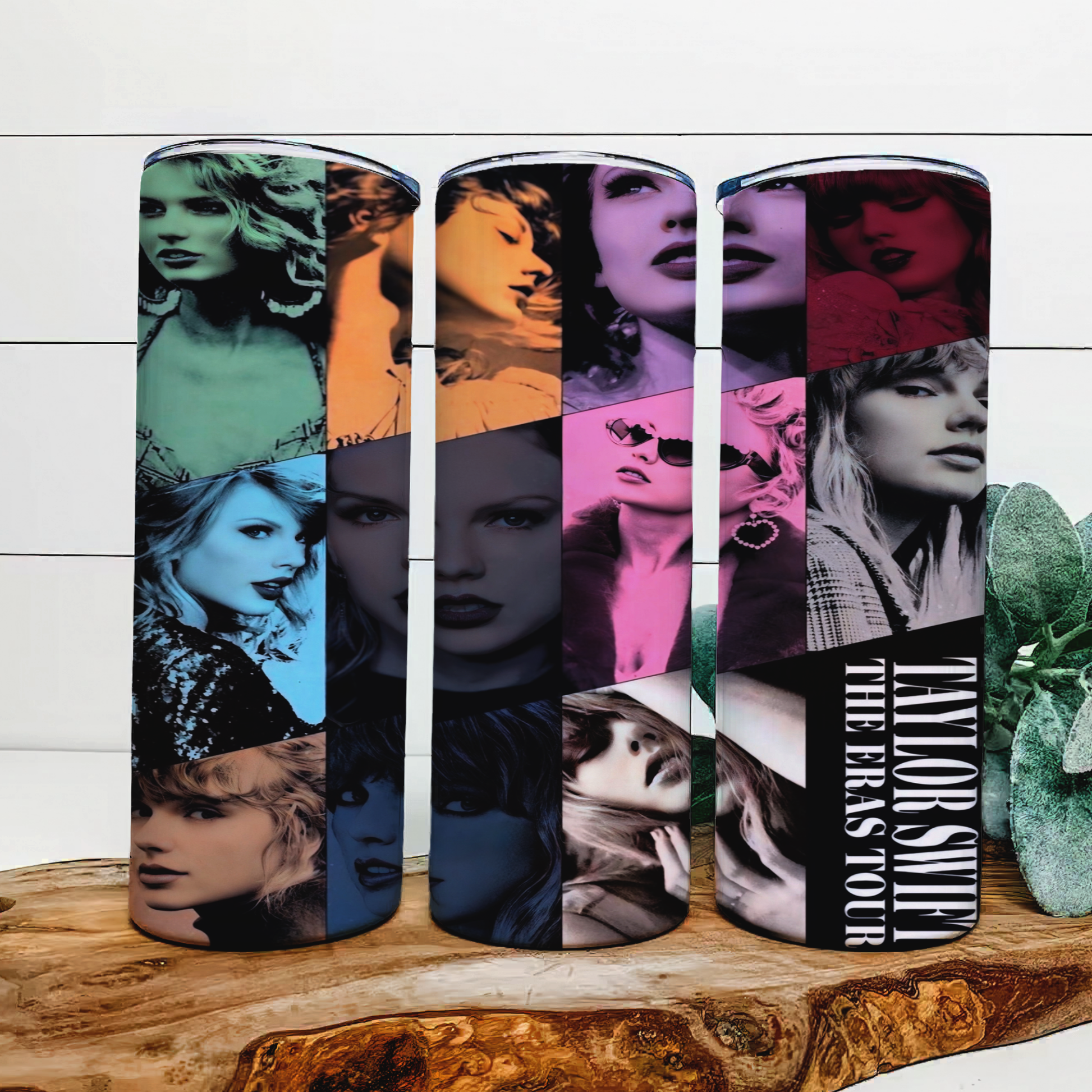 Three Taylor Swift ERAS 20oz Tumblers by Kreative Kreationz showcase artistic portraits of her in different colors, featuring "The Eras Tour." Each tumbler includes a spill-proof lid and reusable straw, placed on a wooden surface with a plant backdrop.